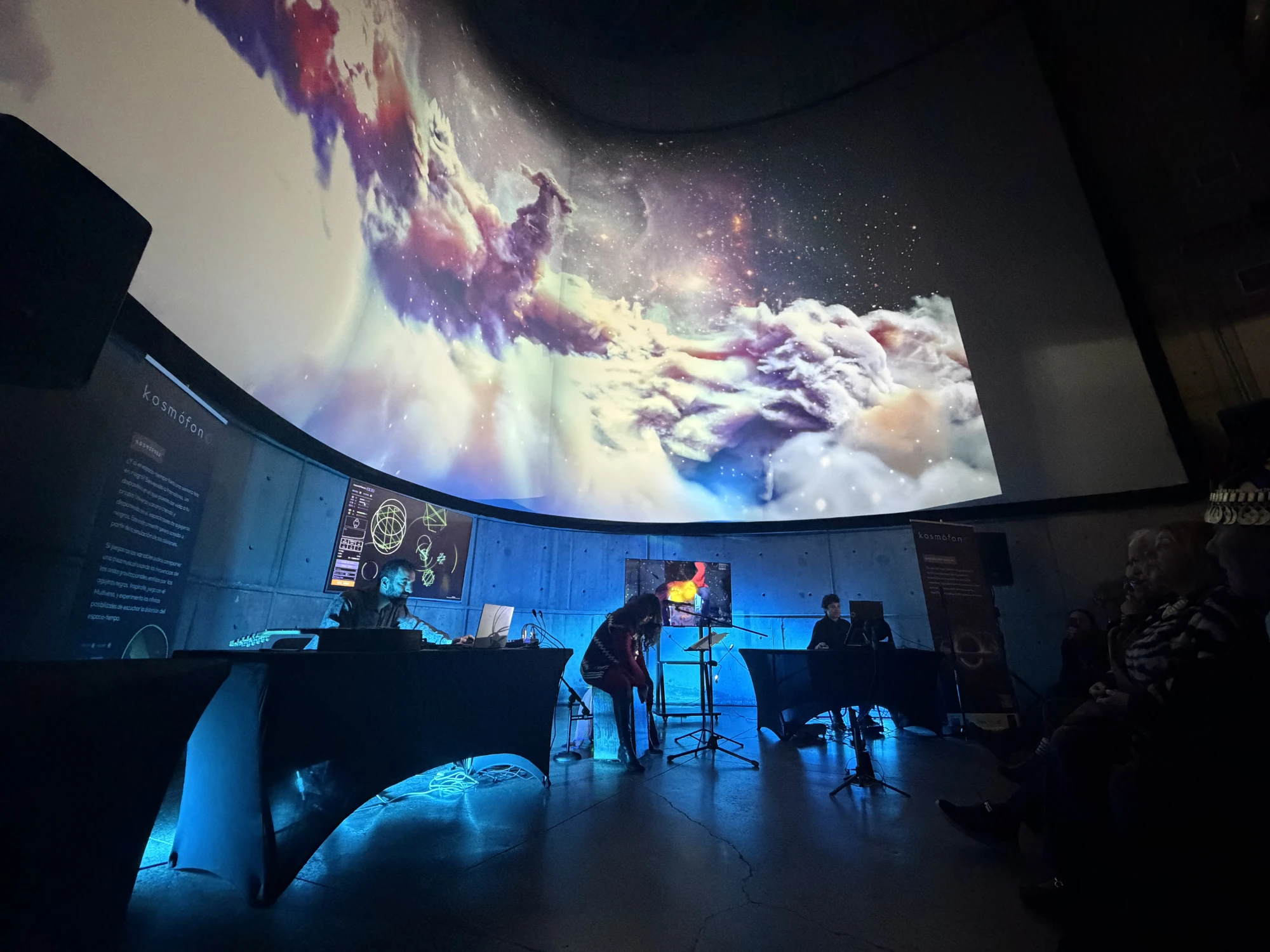 Concierto Kosmófono en el MIM, Santiago: músicos en escena frente a una cúpula con imágenes de nebulosas